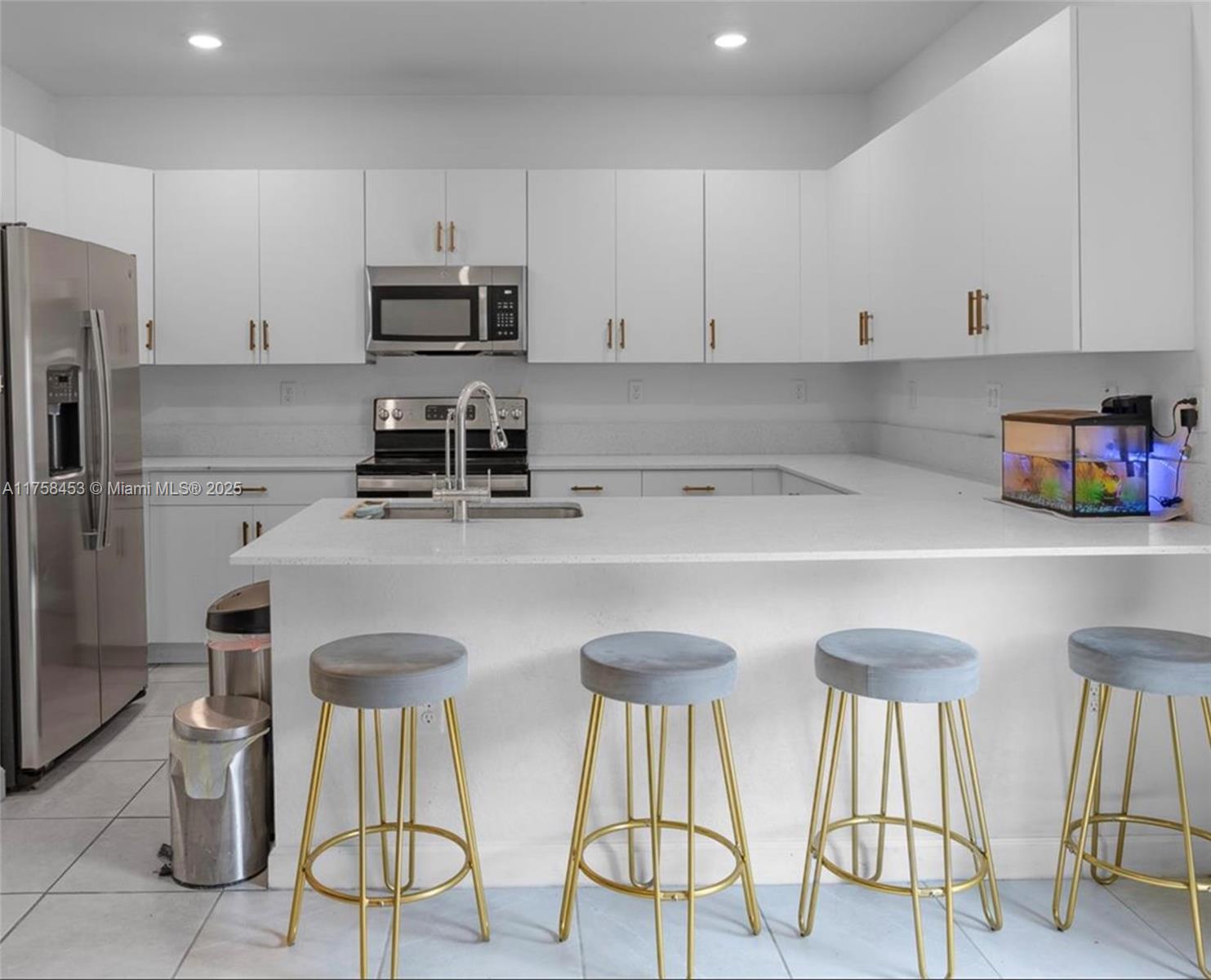11426 West 33rd Way Hialeah, FL 33018 - Photo 8 of 14 a kitchen with stainless steel appliances a white table and chairs in it