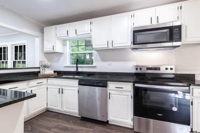 a kitchen with stainless steel appliances granite countertop a sink and a stove
