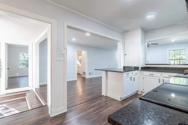 a kitchen with granite countertop a stove a sink and a refrigerator