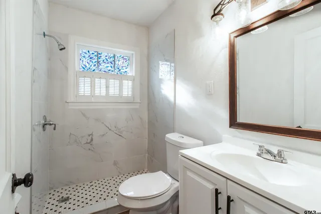 a bathroom with a sink a toilet and shower