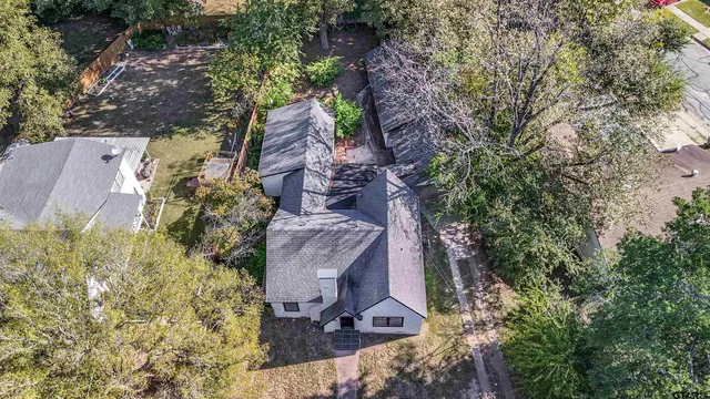 an aerial view of a house with yard and tree s
