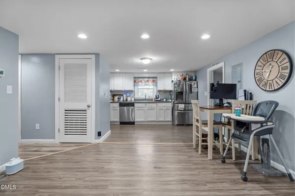 a living room with furniture a flat screen tv and a wooden floor