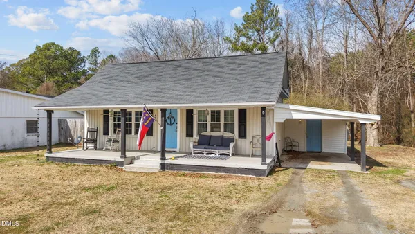 a view of a house with patio and a yard