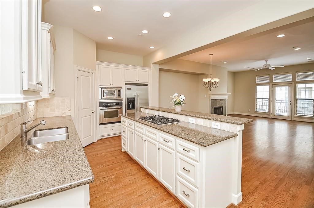 222 Knox Street, Unit F Houston, TX 77007 - Photo 16 of 36 a kitchen with kitchen island granite countertop a stove and a sink