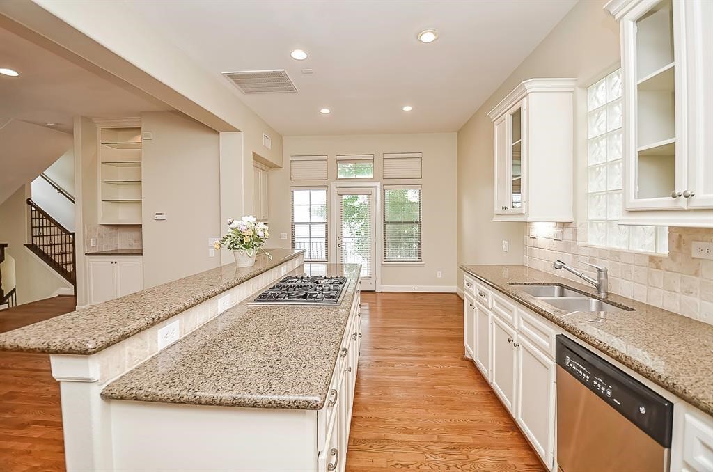 222 Knox Street, Unit F Houston, TX 77007 - Photo 17 of 36 a large kitchen with granite countertop a sink and dishwasher a stove top oven with wooden floor