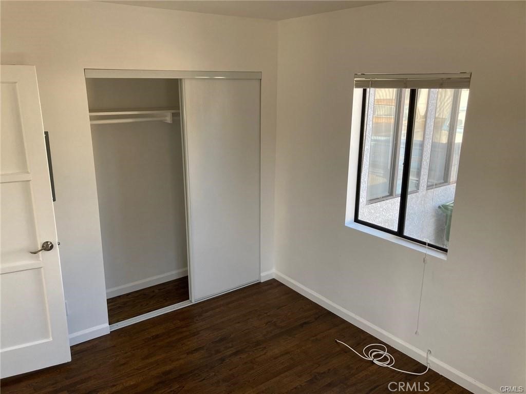 8312 Barnsley Avenue Los Angeles, CA 90045 - Photo 10 of 17 an empty room with wooden floor closet and windows