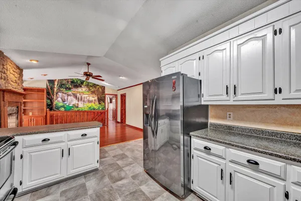a large kitchen with stainless steel appliances granite countertop a refrigerator and a sink