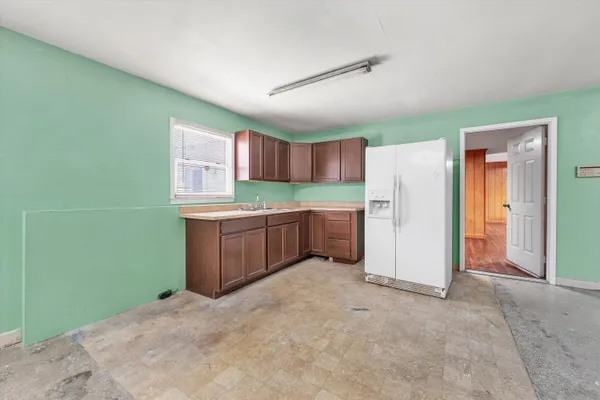 a view of a yard with plants and wooden fence