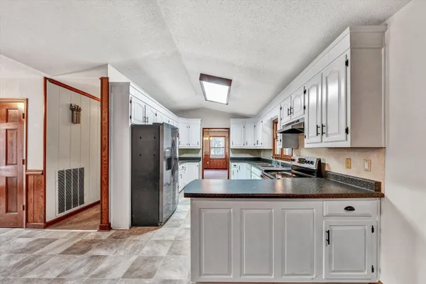 a kitchen with white cabinets and white appliances