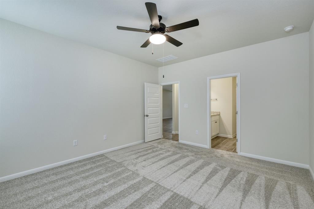 8307 Haflinger Drive Austin, TX 78747 - Photo 3 of 13 Unfurnished bedroom featuring a ceiling fan, light colored carpet, and ensuite bathroom