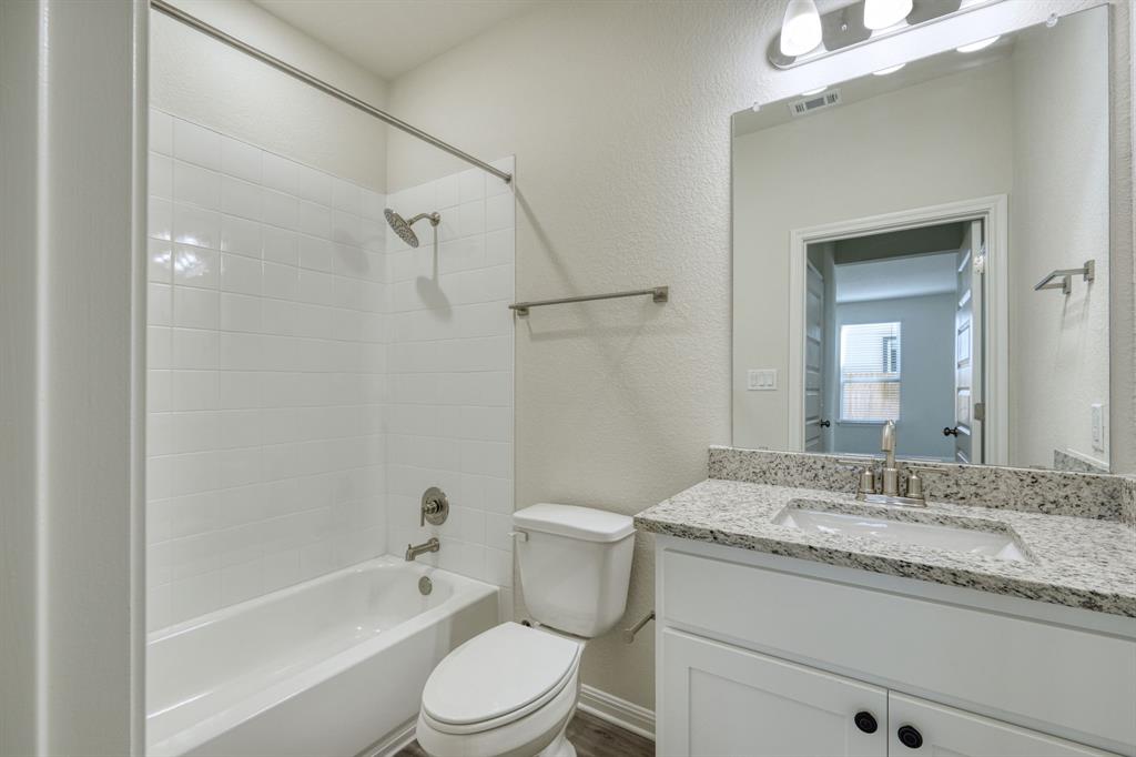 8307 Haflinger Drive Austin, TX 78747 - Photo 6 of 13 Full bathroom with shower combination, vanity, and a textured wall