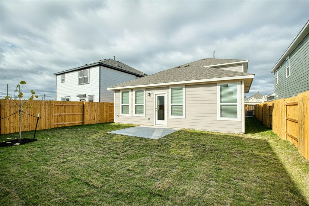 8307 Haflinger Drive Austin, TX 78747 - Photo 10 of 13 Back of property with a patio area, a fenced backyard, and a shingled roof