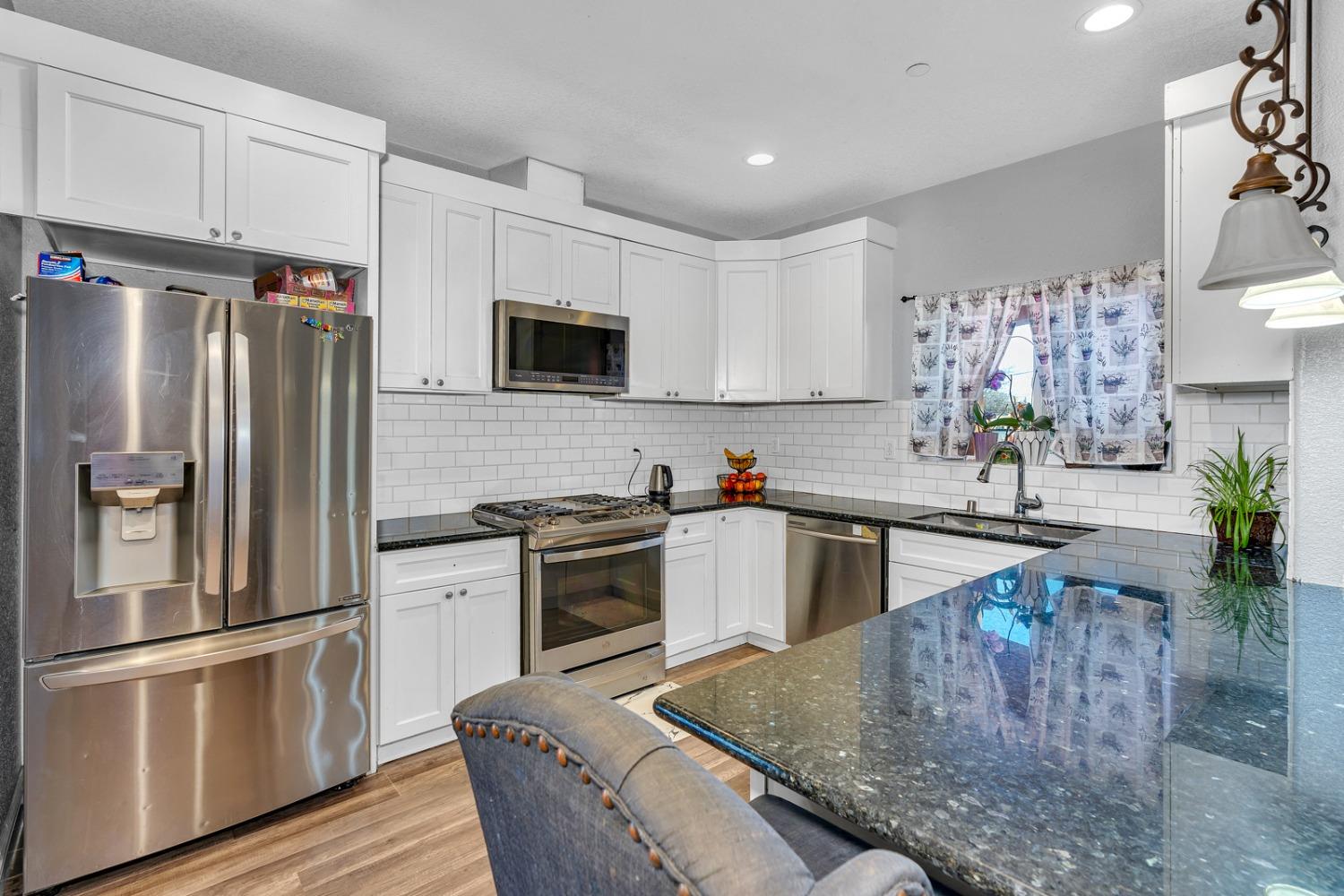 509 Kerr Avenue Modesto, CA 95354 - Photo 19 of 55 a kitchen with granite countertop a refrigerator stove and sink