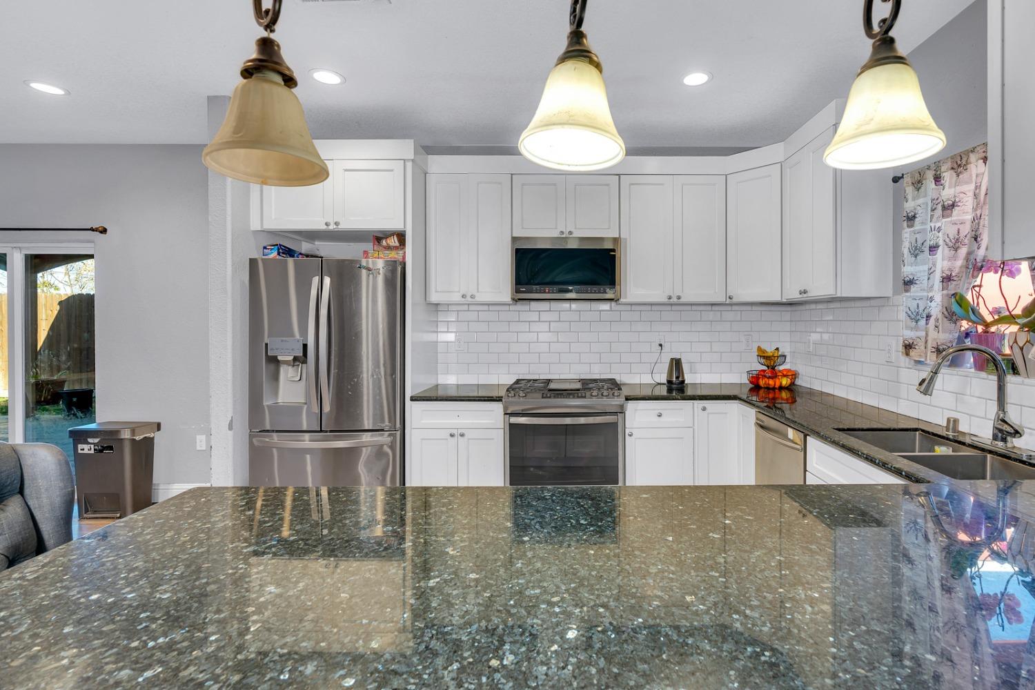 509 Kerr Avenue Modesto, CA 95354 - Photo 22 of 55 a kitchen with stainless steel appliances granite countertop a sink refrigerator and microwave