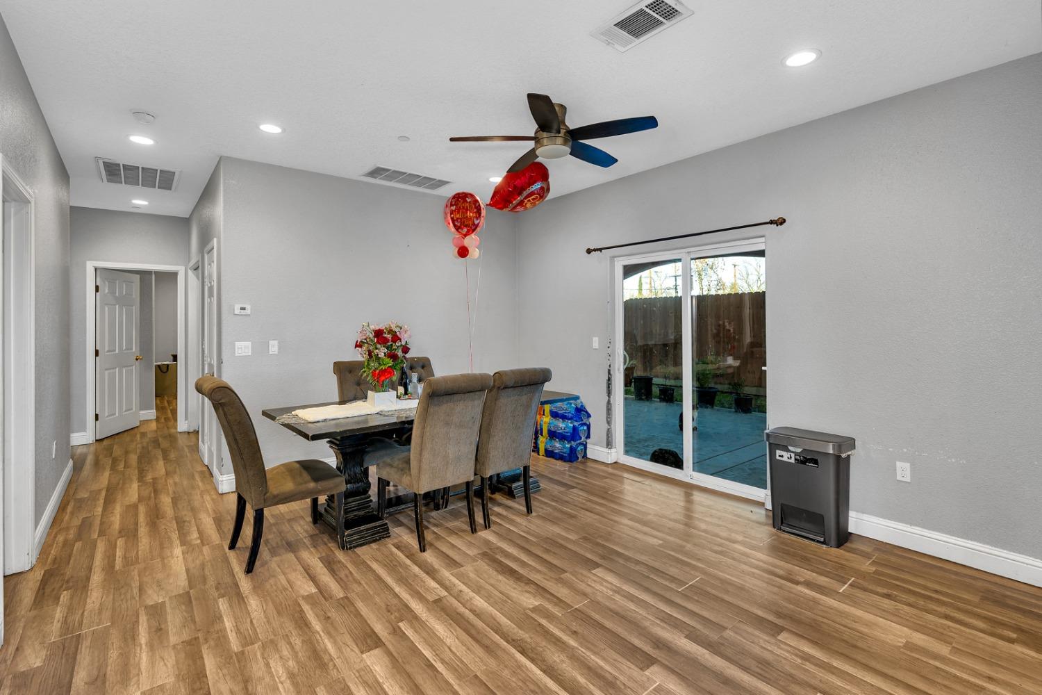 509 Kerr Avenue Modesto, CA 95354 - Photo 23 of 55 a dining room with wooden floor a chandelier a glass table and chairs