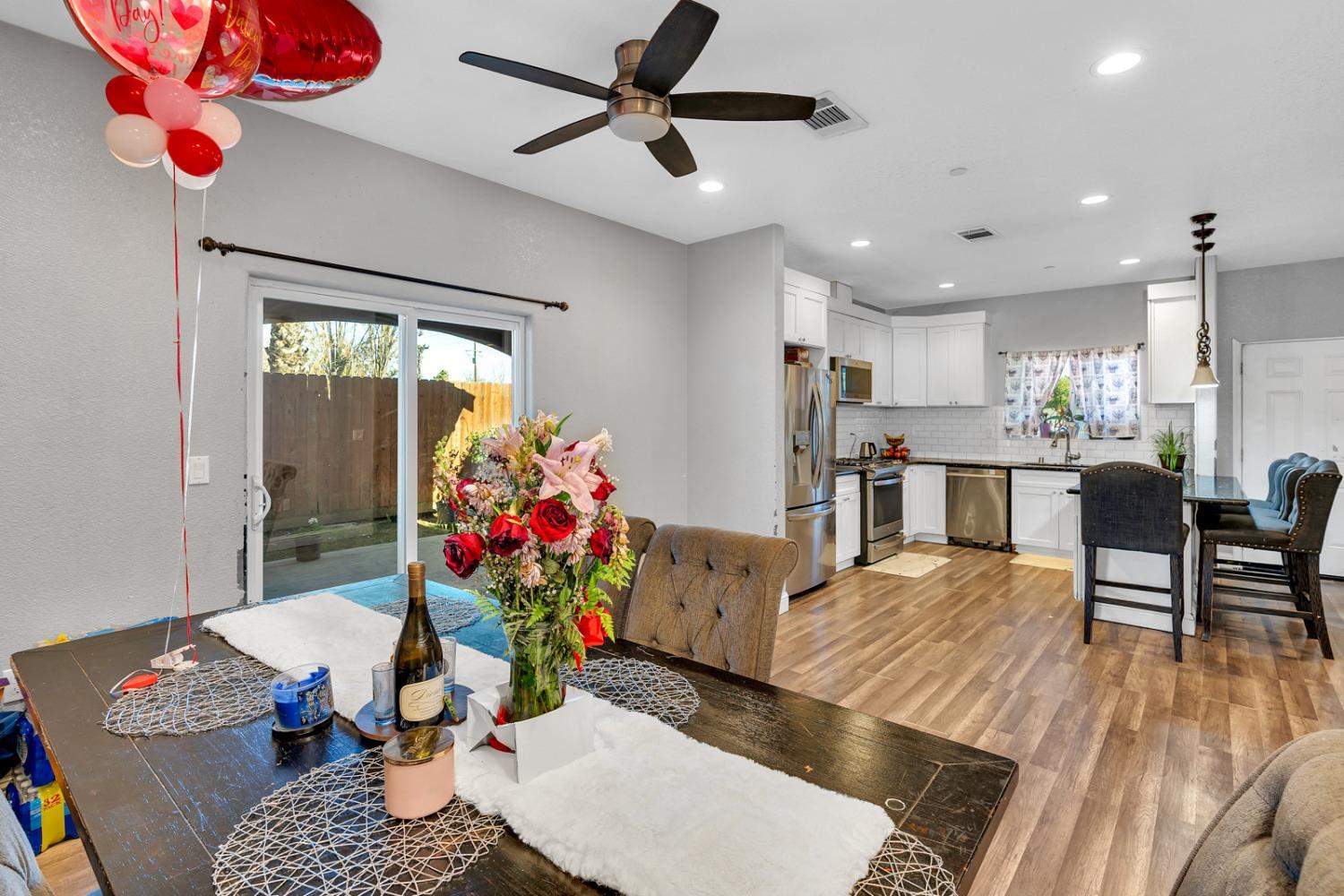 509 Kerr Avenue Modesto, CA 95354 - Photo 25 of 55 a living room with furniture dining table a chandelier and a dining table with wooden floor