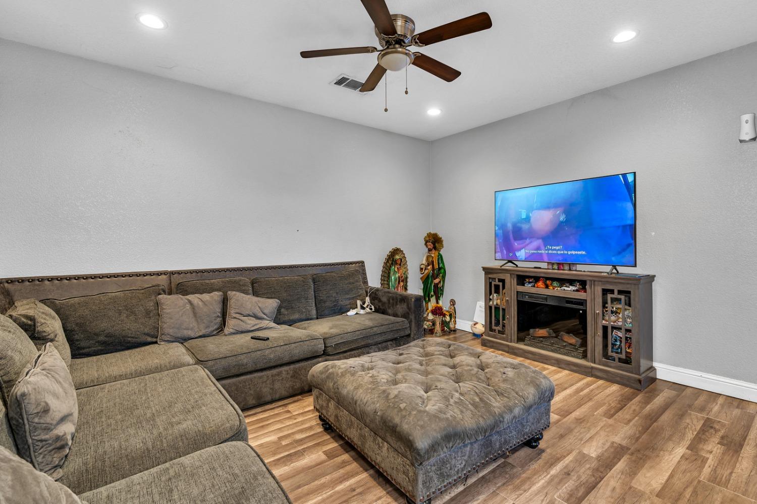 509 Kerr Avenue Modesto, CA 95354 - Photo 28 of 55 a living room with furniture a fireplace and a flat screen tv