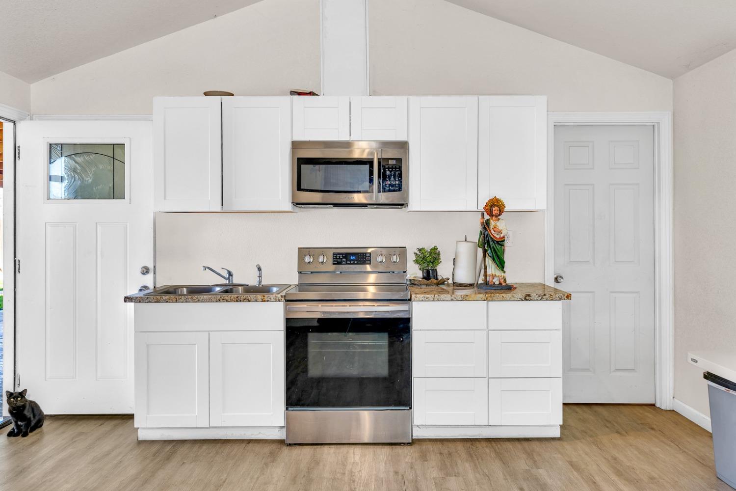 509 Kerr Avenue Modesto, CA 95354 - Photo 41 of 55 a kitchen with stainless steel appliances granite countertop a stove and white cabinets