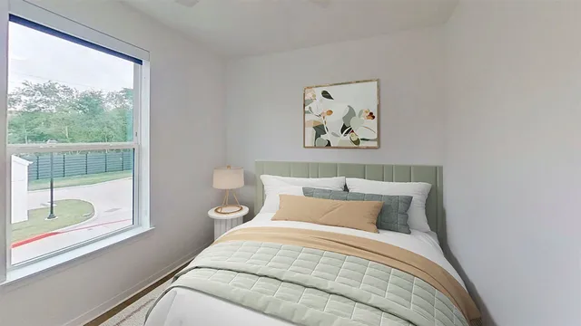 a bedroom with a bed and a painting on the wall