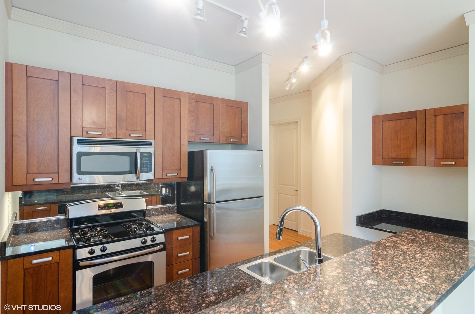 170 West Polk Street, Unit 906 Chicago, IL 60605 - Photo 7 of 18 a kitchen with granite countertop a stove a refrigerator and a stove top oven