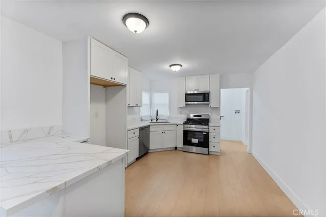 a kitchen with a refrigerator a stove top oven a sink dishwasher and wooden cabinets