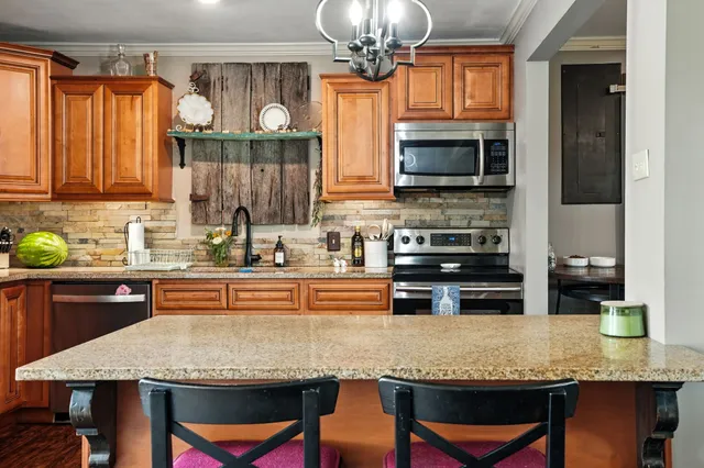 a kitchen with stainless steel appliances granite countertop a sink counter space and appliances