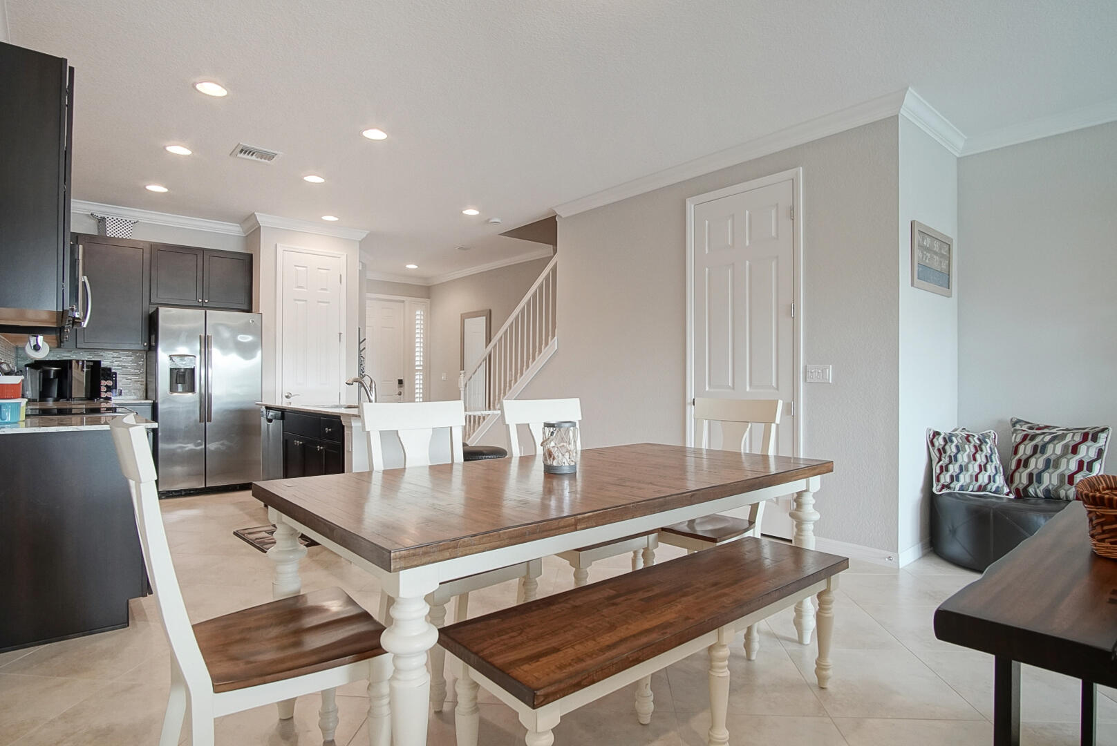 638 Southwest Glen Crest Way Stuart, FL 34997 - Photo 11 of 32 a large kitchen with a table chairs and a refrigerator