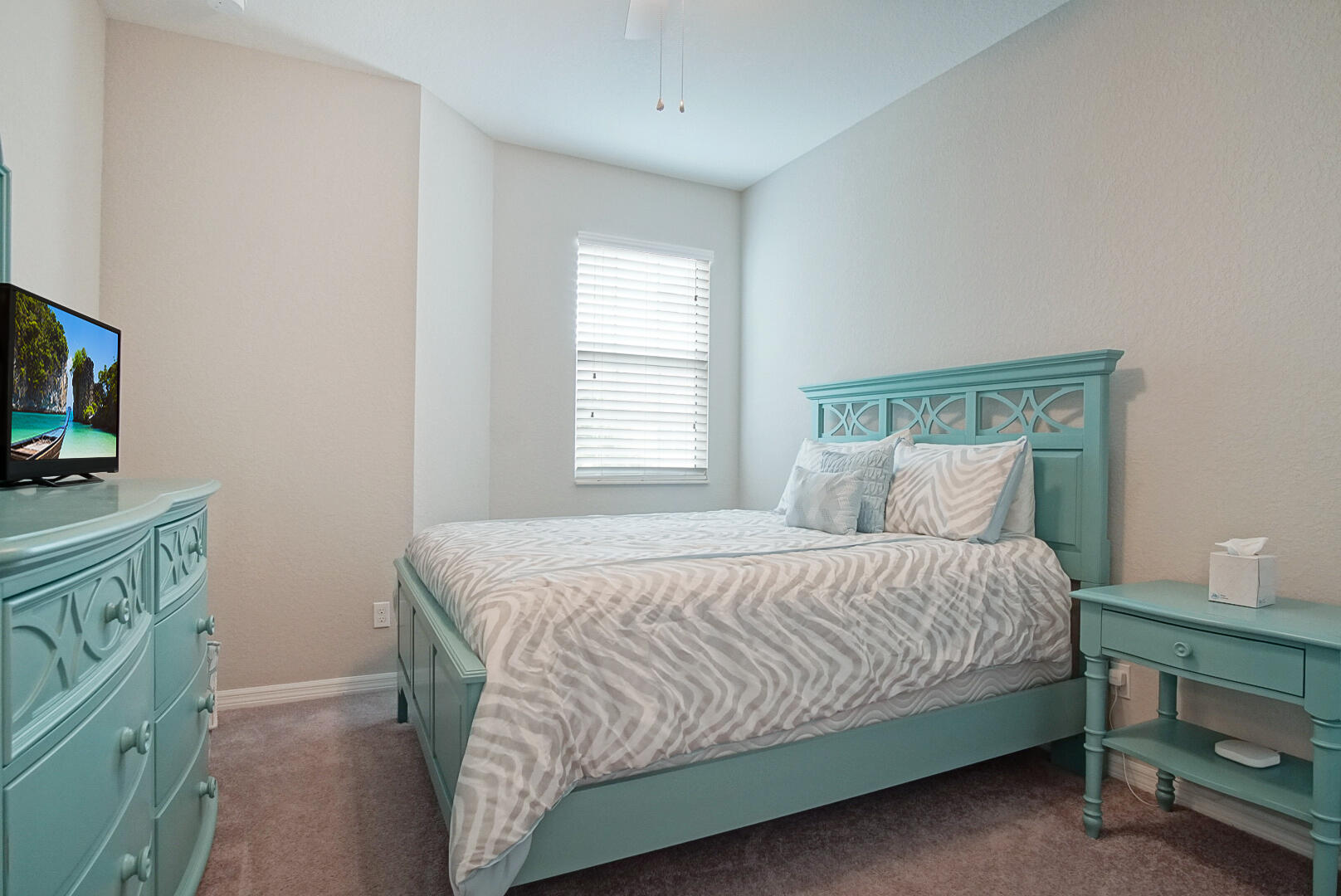 638 Southwest Glen Crest Way Stuart, FL 34997 - Photo 21 of 32 a bedroom with a bed and a flat tv screen on a dresser