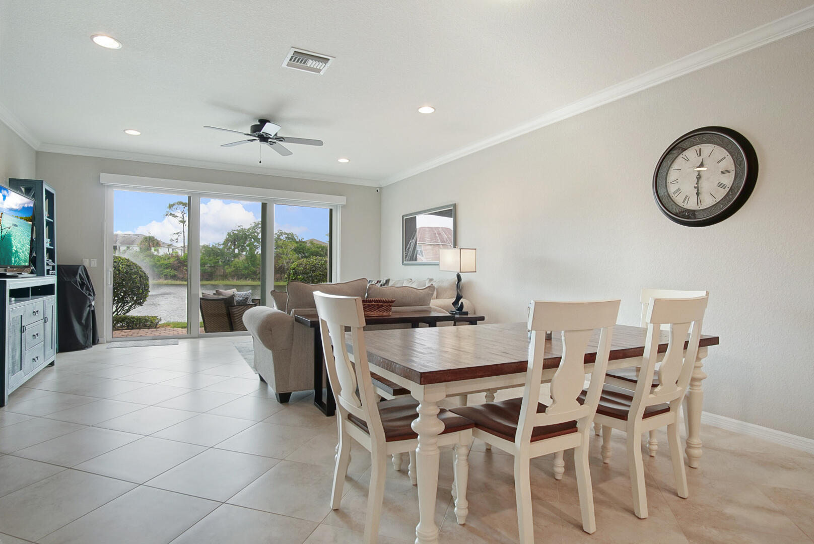 638 Southwest Glen Crest Way Stuart, FL 34997 - Photo 10 of 32 a dining room with furniture a large window and a clock