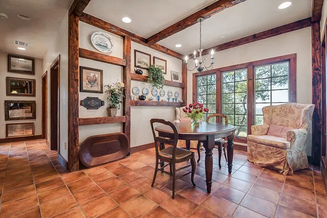 a dining room with furniture and large windows