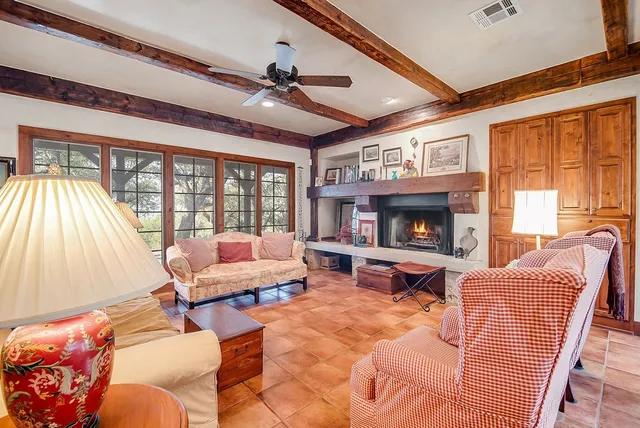 a living room with furniture fireplace and a large window