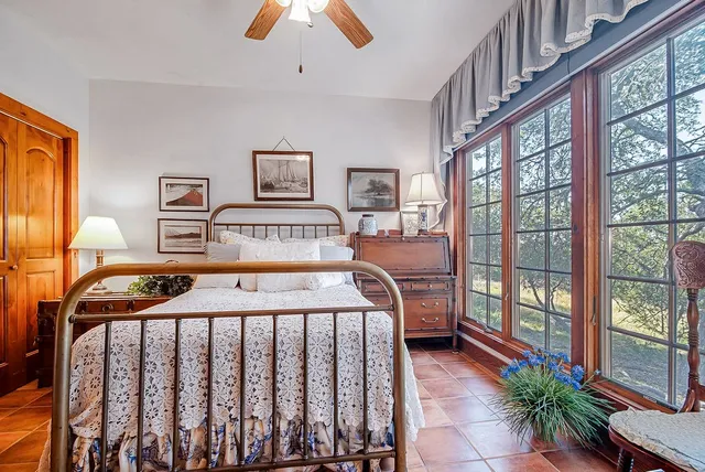 a bedroom with a bed and a large window