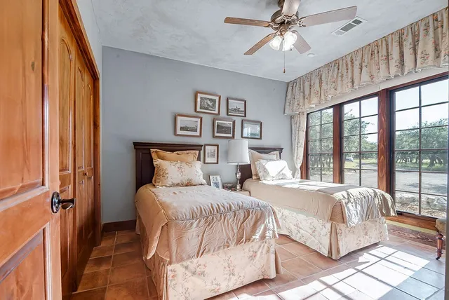 a spacious bedroom with a large bed and a chandelier