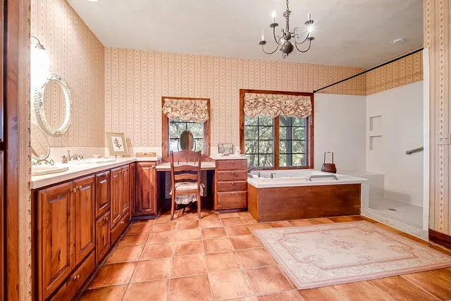 a large spacious bathroom with a tub sink and mirror