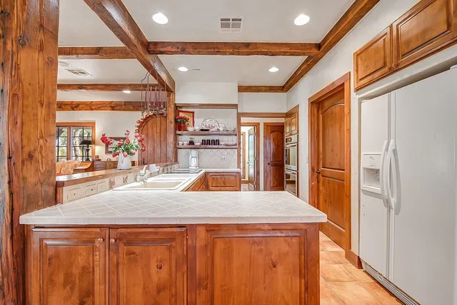 a large kitchen with stainless steel appliances a large window and a counter top space