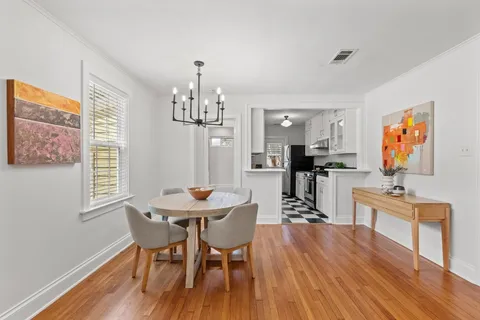 a view of a dining room with furniture wooden floor and chandelier