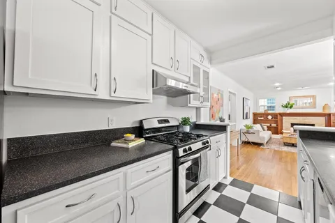 a kitchen with stainless steel appliances granite countertop a stove a sink and a white cabinets