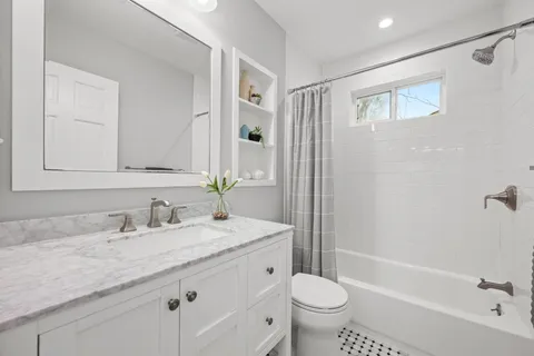 a bathroom with a granite countertop sink toilet and shower