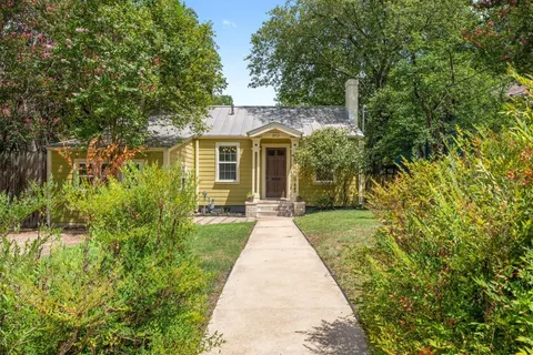 front view of a house with a yard and potted plants