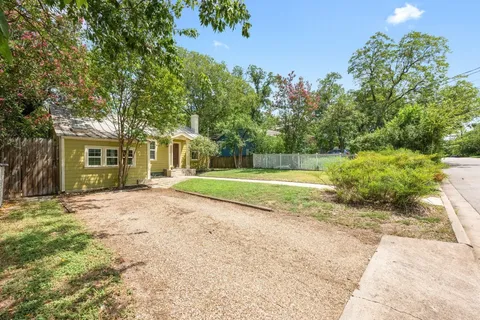 a view of a house with a big yard and large trees