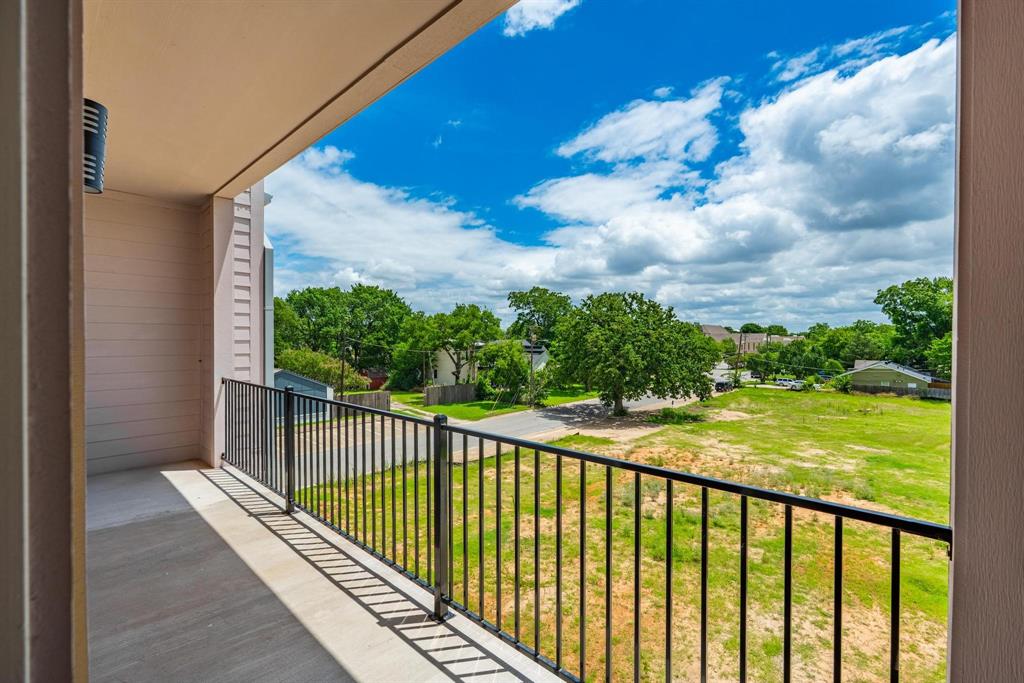 508 South O Connor Road Irving, TX 75060 - Photo 19 of 21 Private balcony with concrete flooring and black metal railing, featuring a verdant landscape with mature trees