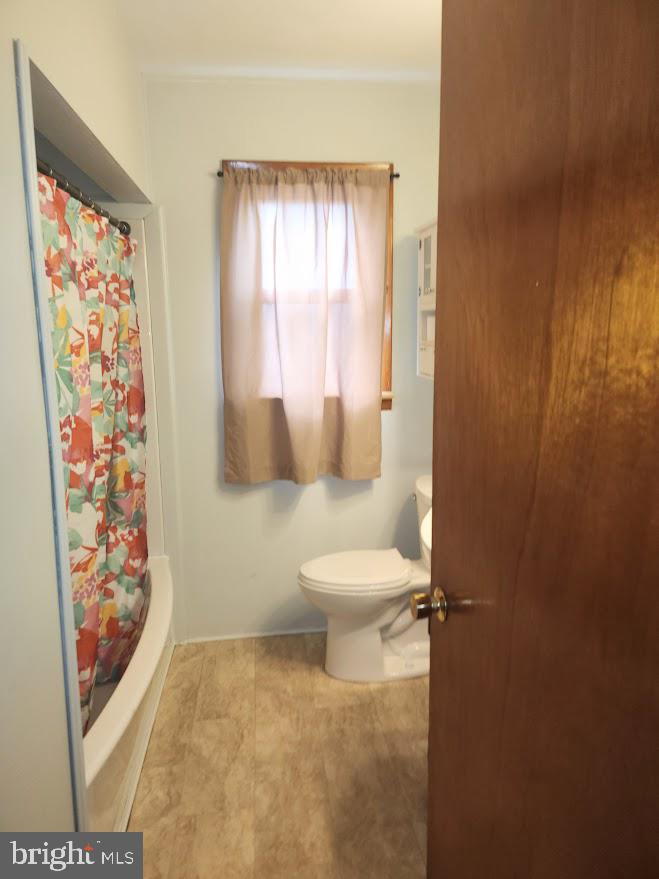 10314 Hyndman Road Manns Choice, PA 15550 - Photo 21 of 54 a white toilet sitting next to a shower curtain