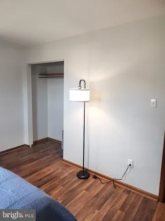 a view of a room with wooden floor and a ceiling fan