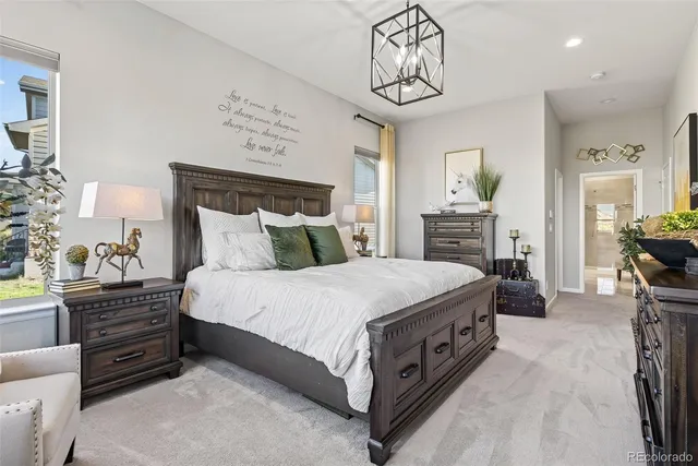 a spacious bedroom with a bed and a chandelier