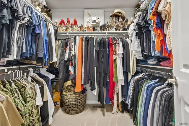 a view of walk in closet with clothes