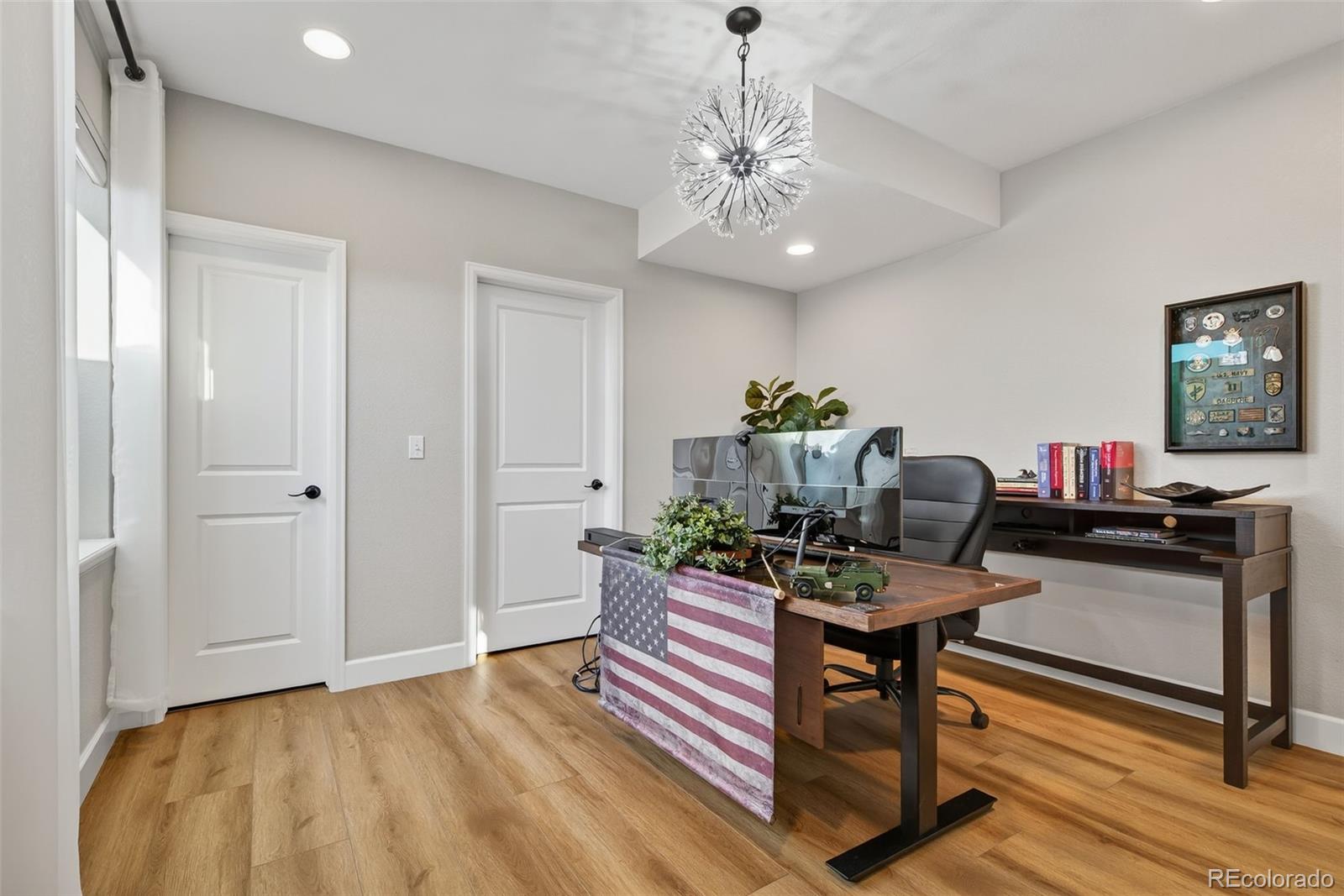 14094 Ivy Court Thornton, CO 80602 - Photo 25 of 44 a view of a workspace with furniture and wooden floor