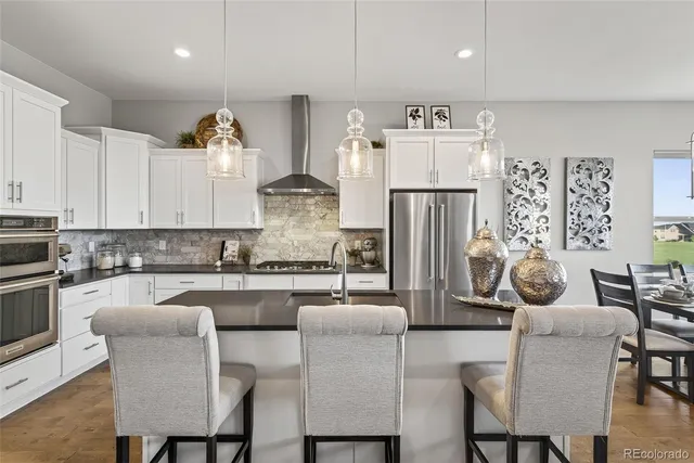 a kitchen with refrigerator and chairs