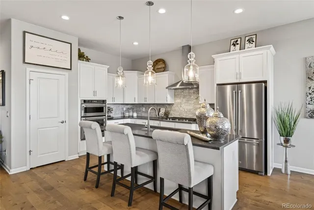 a kitchen with stainless steel appliances kitchen island granite countertop a refrigerator and a stove top oven