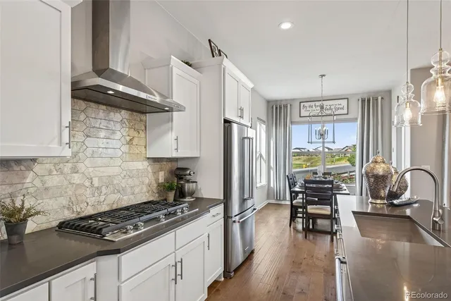 a kitchen with stainless steel appliances a stove a sink and a refrigerator