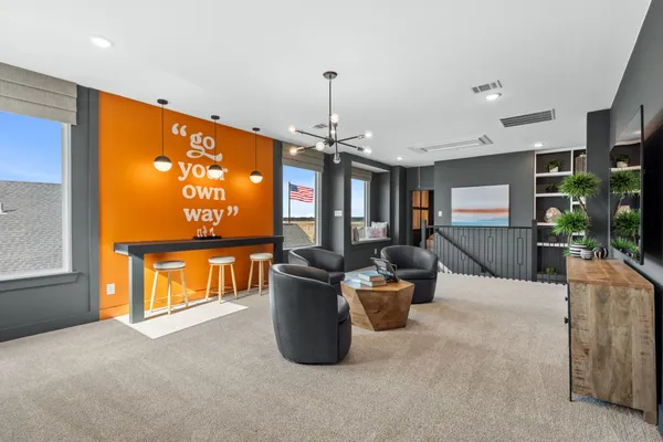 a living room with furniture a flat screen tv and a chandelier